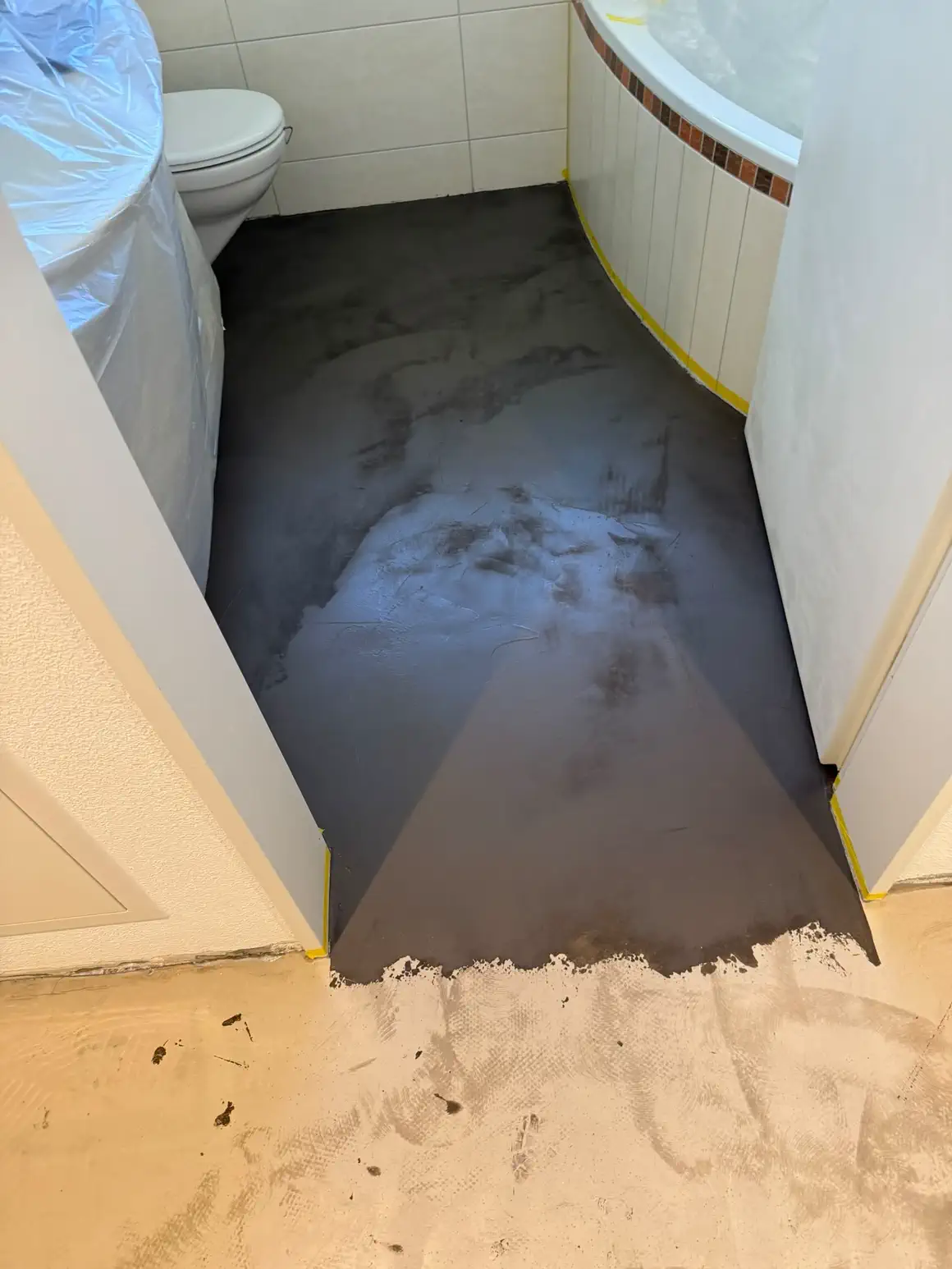 Frisch gespachtelter und grundierter Badezimmerboden vor dem Plattenbelag