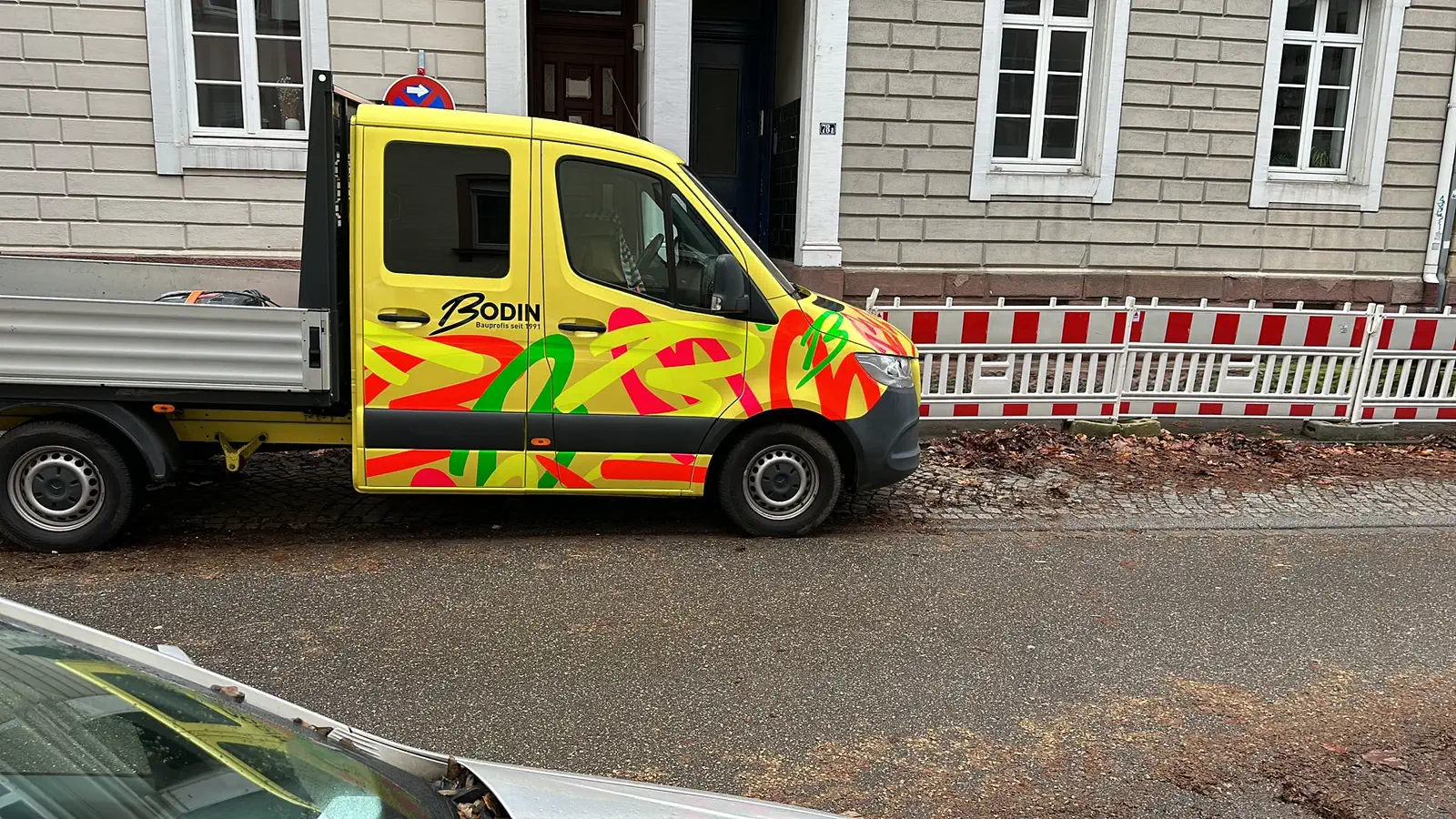 Firmenfahrzeug von Bodin Bau mit farbiger Beschriftung auf einer Baustelle